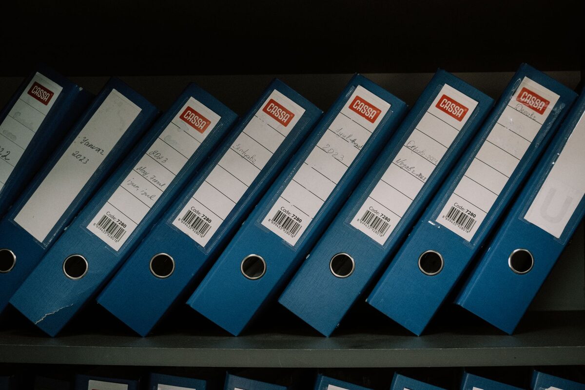 Segregatory z dokumentami ustawione rzędem na półce archiwum