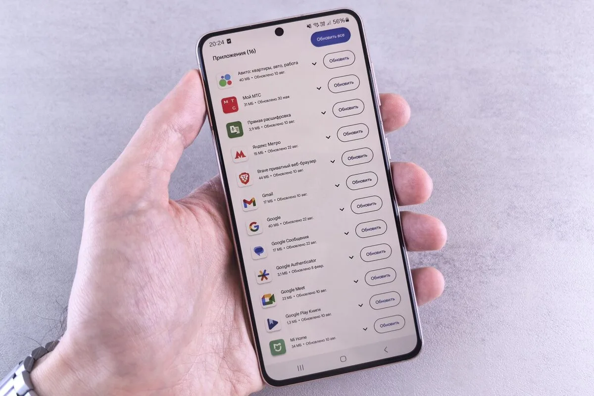 Dłoń trzymająca telefon z listą aplikacji do aktualizacji