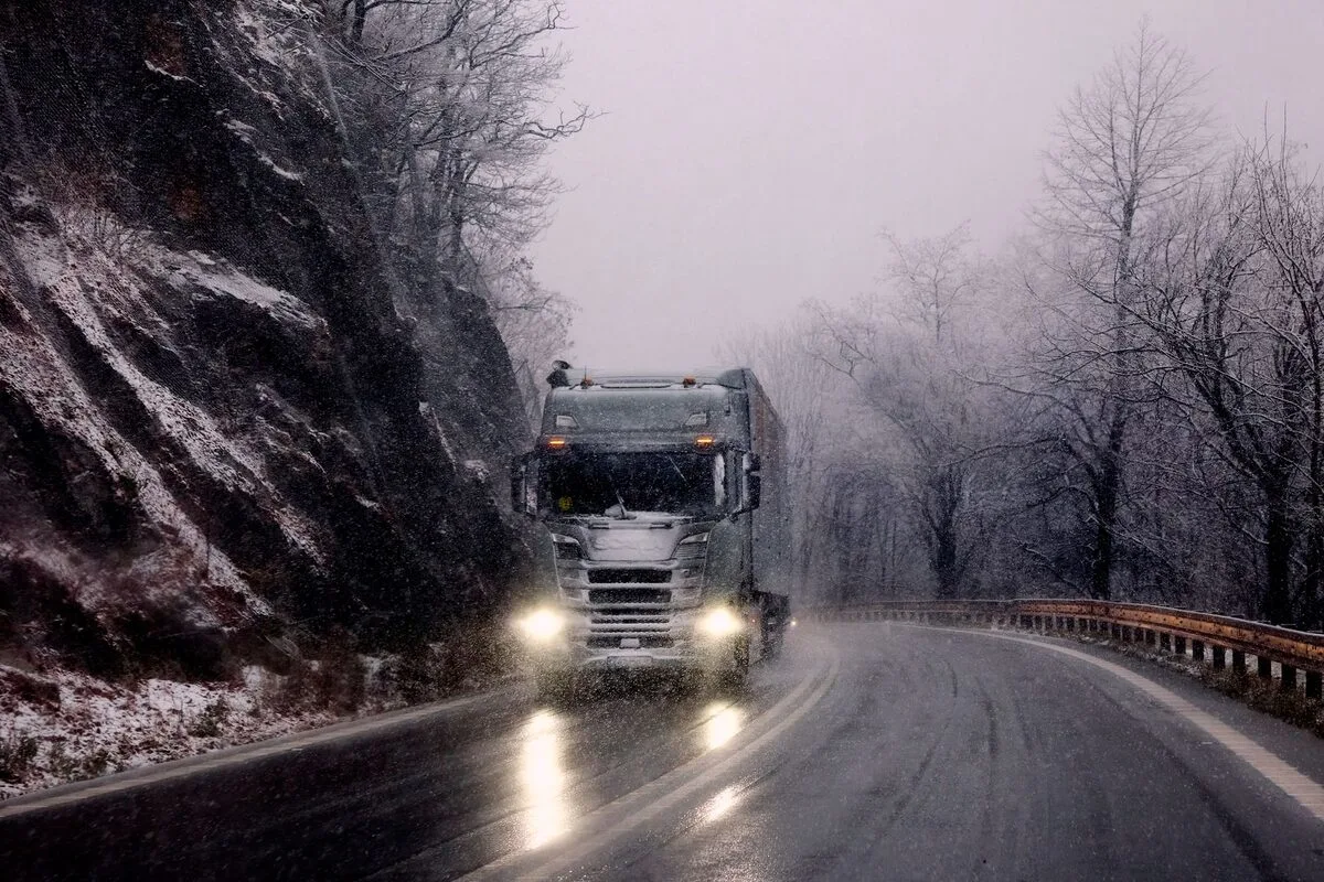 Ciężarówka na zaśnieżonej drodze o świcie