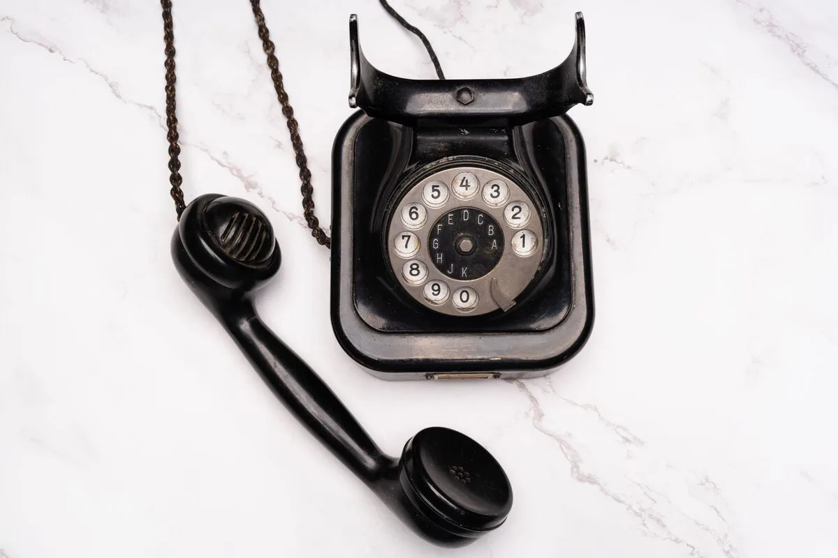Telefon tarczowy ze słuchawką odłożoną obok