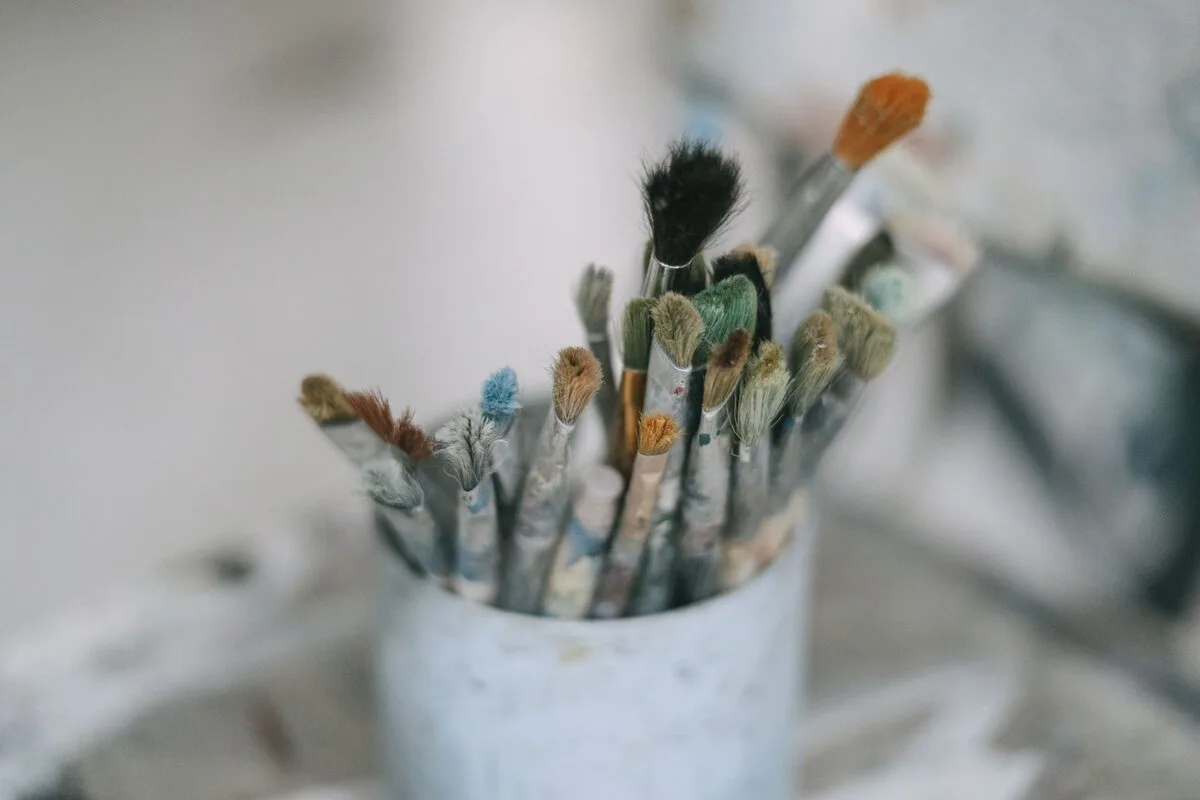 Pędzle malarskie włożone do ceramicznego kubka