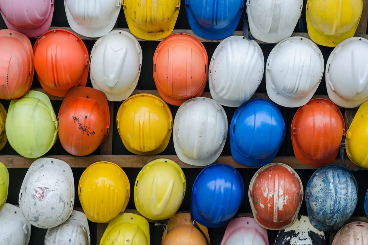 Kolorowe kaski ochronne ułożone rzędami