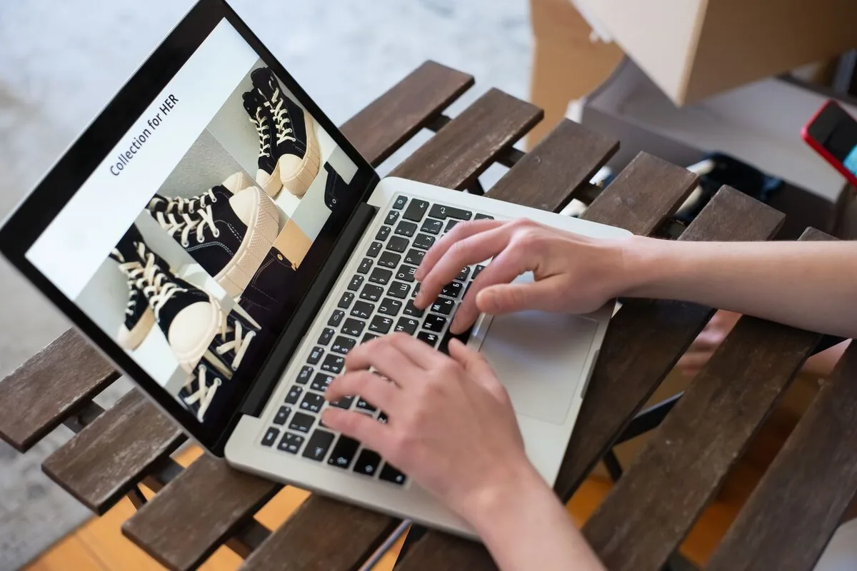 Dłonie przy laptopie z otwartym sklepem internetowym